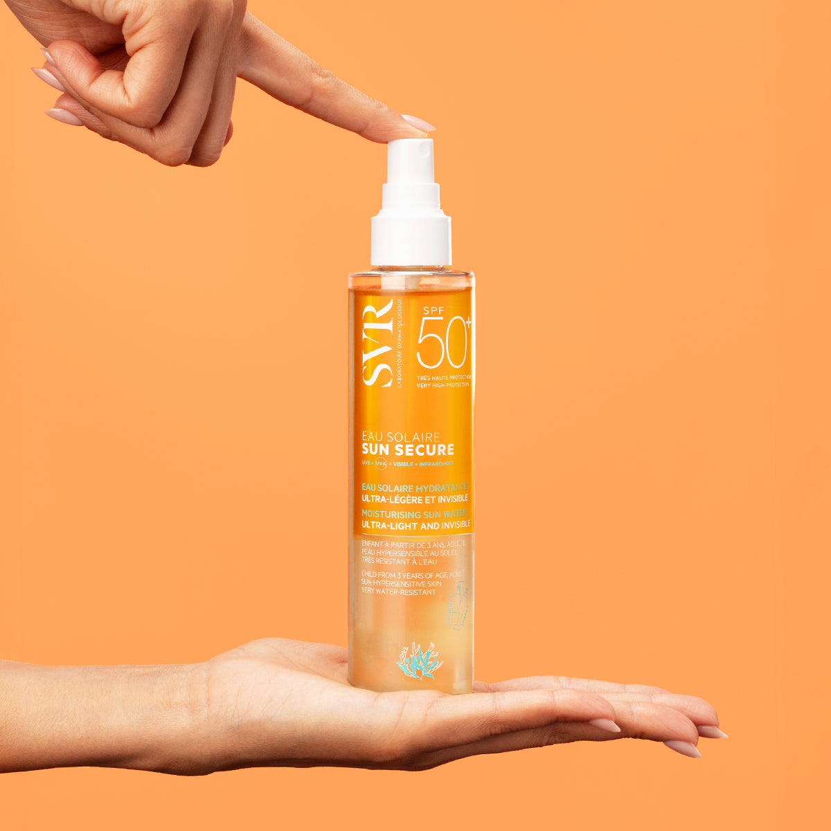 Flacon spray SVR SUN SECURE Eau Solaire SPF50+ bi-phasé tenu entre deux mains sur fond orange vif.