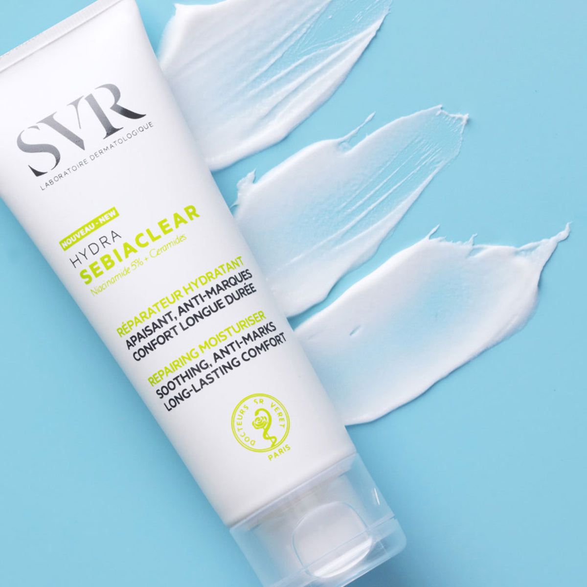 Tube de soin hydratant SVR Sebiaclear Hydra blanc avec des textures de crème étalées sur un fond bleu clair.