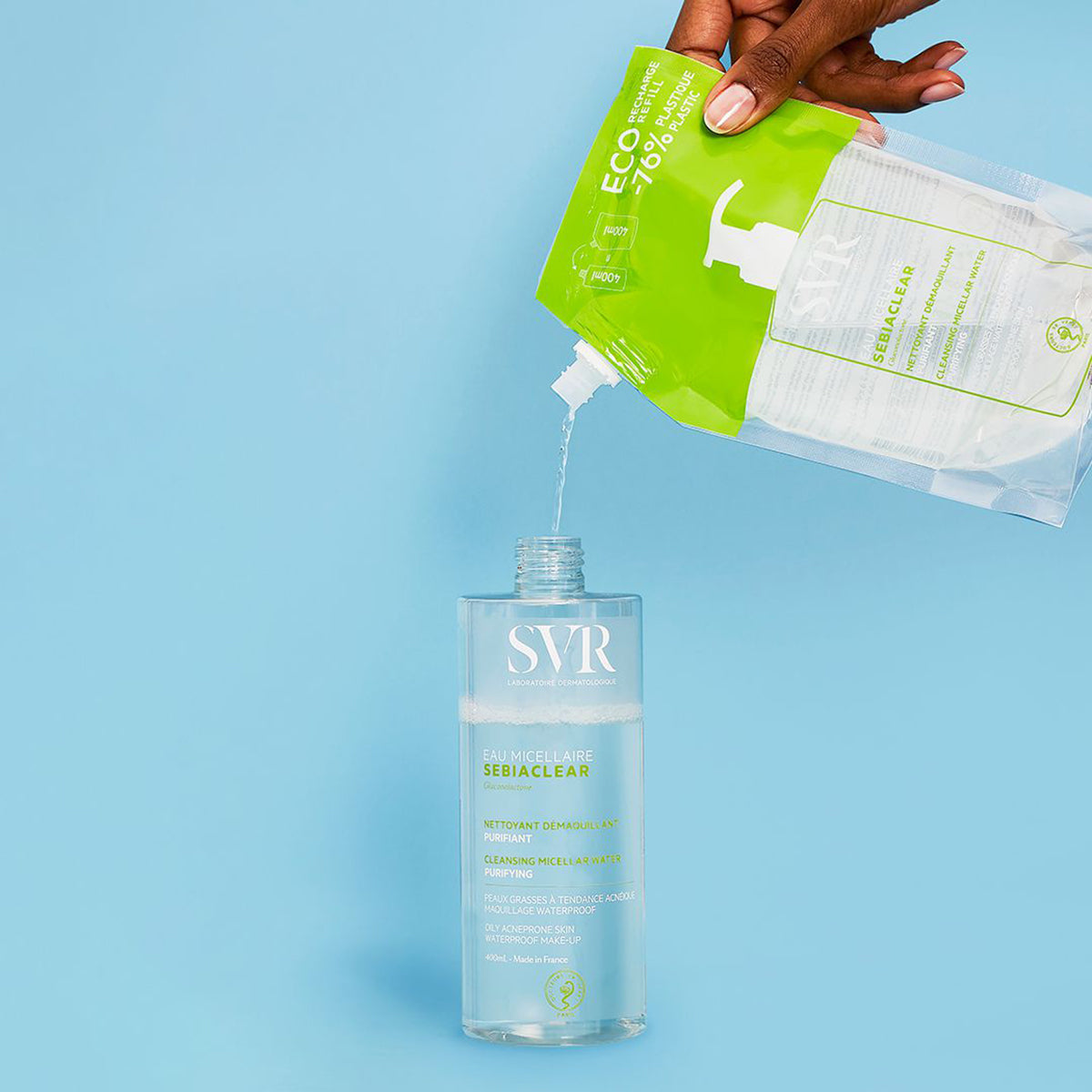 Recharge éco SEBIACLEAR SVR versant l'eau micellaire purifiante dans son flacon transparent sur fond bleu.