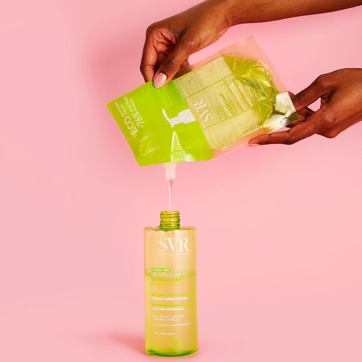 Recharge éco-responsable SVR Sebiaclear Gel Moussant versée dans un flacon pompe transparent sur fond rose.