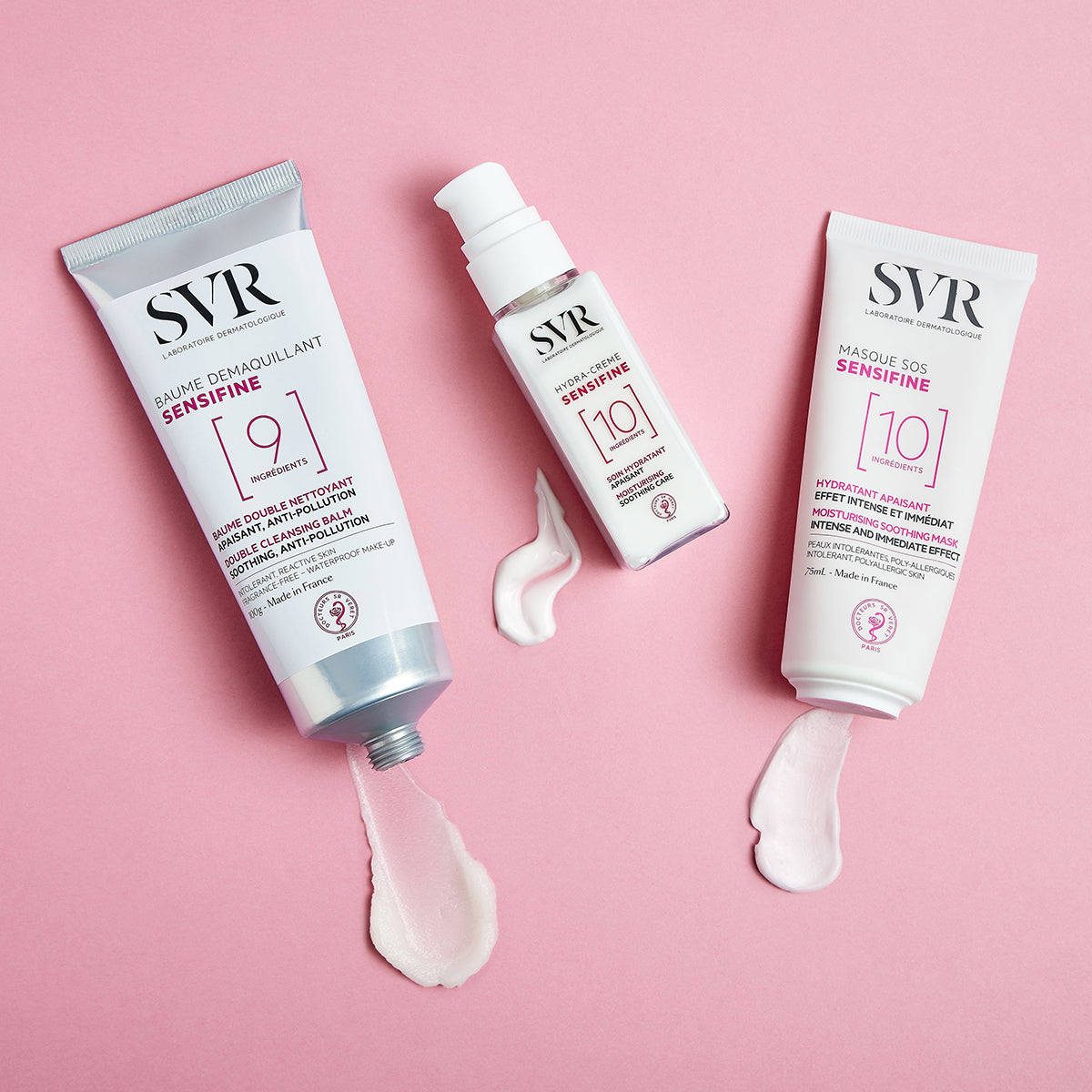 Trois produits SVR Sensifine blancs avec des textures crème sur fond rose, incluant le baume démaquillant, la crème et le masque.