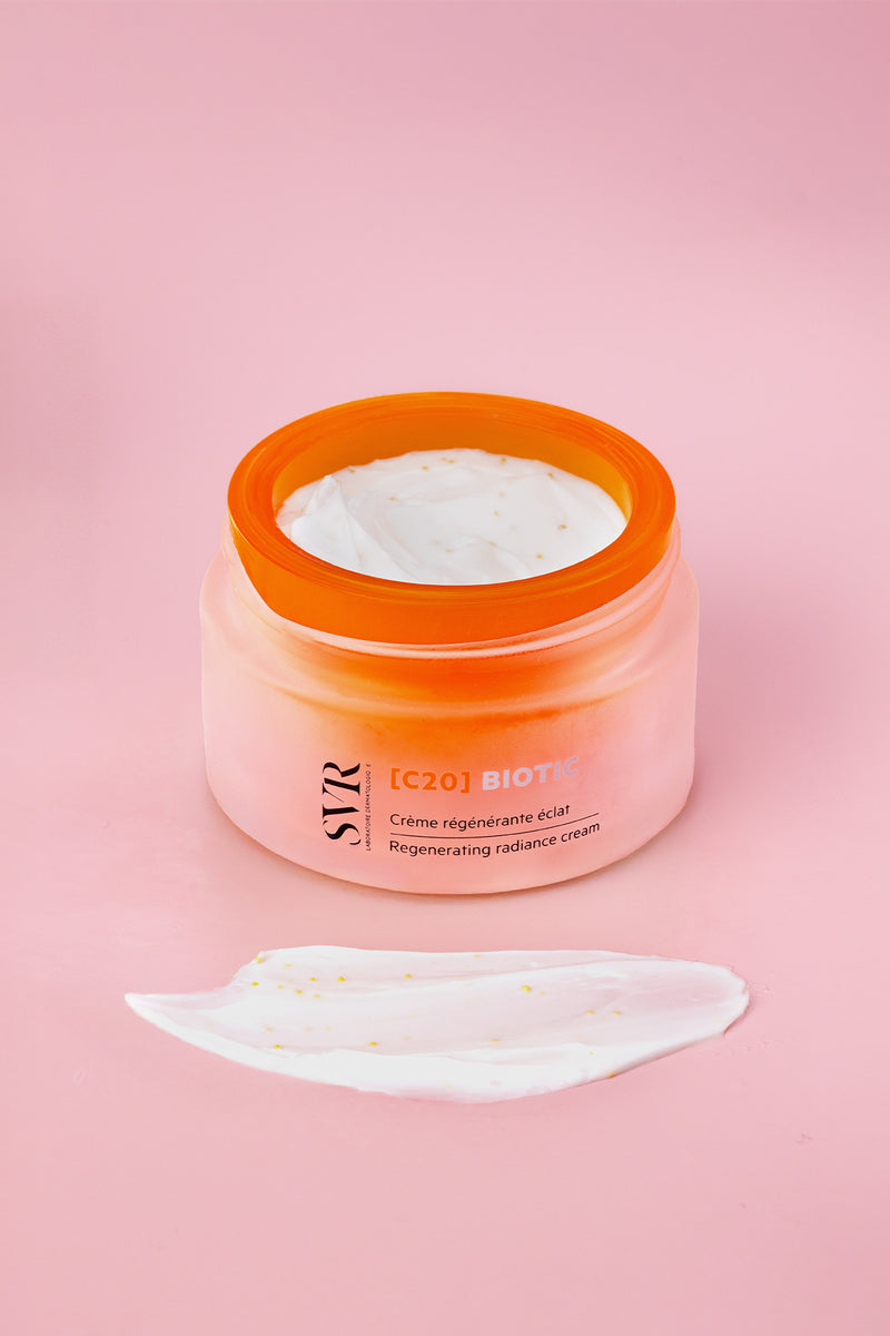 SVR C20 Biotic regenerating radiance cream in a frosted orange jar with a white textured cream smear on a pink background.