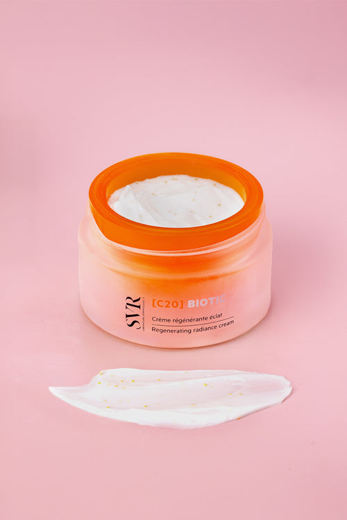 SVR C20 Biotic regenerating radiance cream in a frosted orange jar with a white textured cream smear on a pink background.