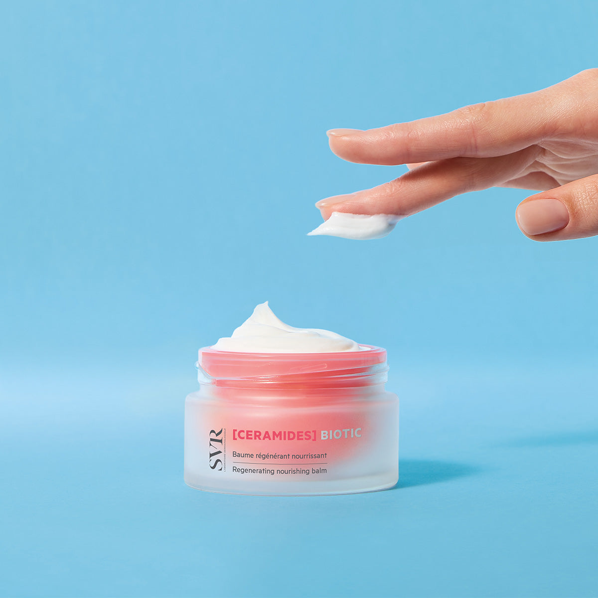 SVR CERAMIDES Biotic regenerating nourishing balm in a frosted glass jar with a pink lid and creamy white texture.