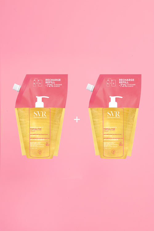 Two 1L SVR Topialyse Huile Lavante refill pouches in yellow and pink packaging on a pink background.