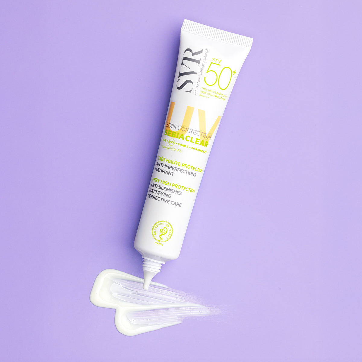 Tube blanc de crème solaire SVR Sebiaclear SPF50+ avec une noisette de texture crémeuse sur fond violet pastel.